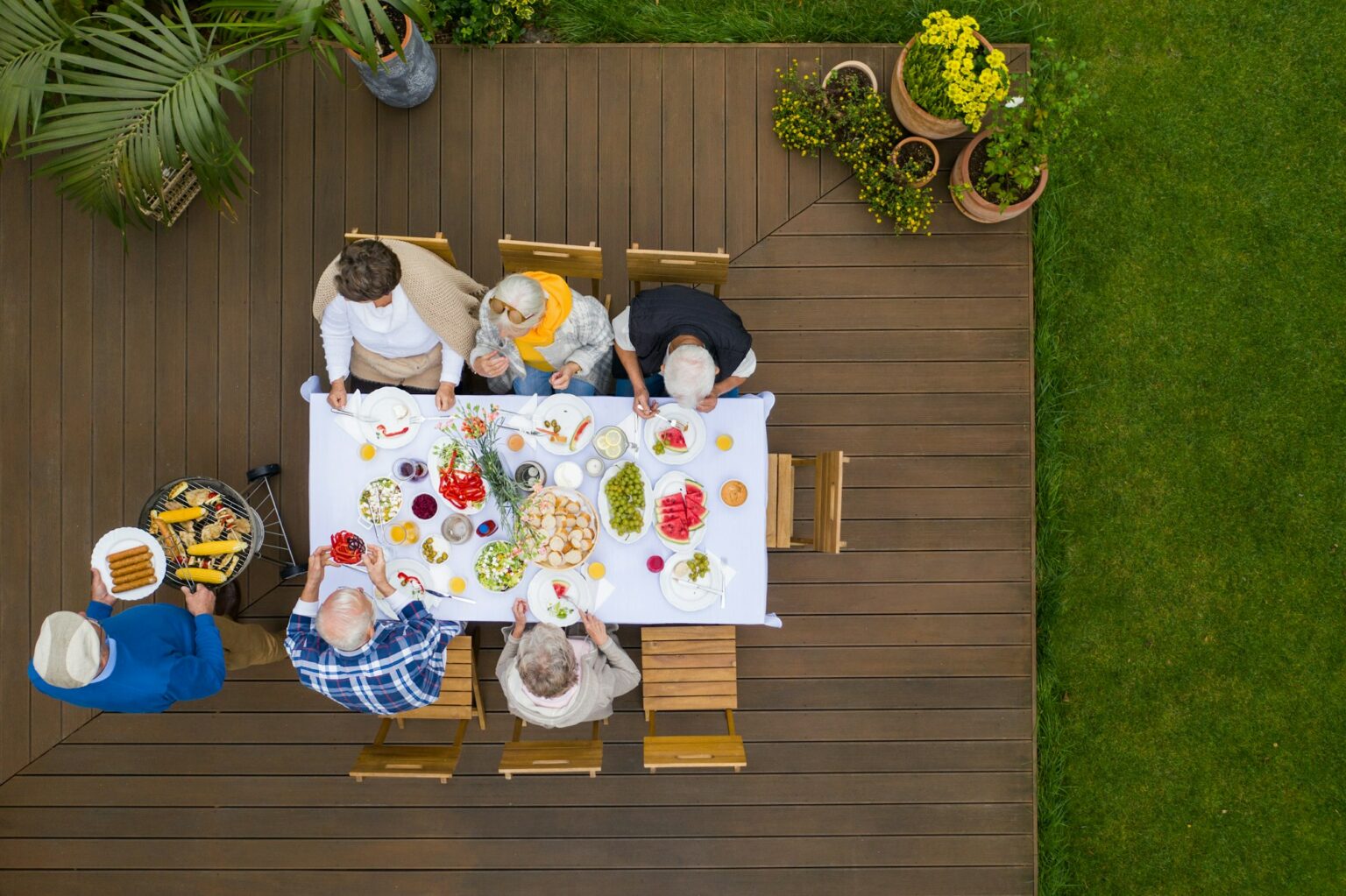 Top view of terrace with table full of food and seniors sitting at it