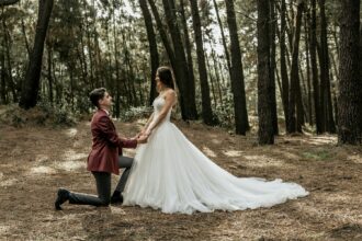 Man kneeling making a marriage proposal to happy bride in forest