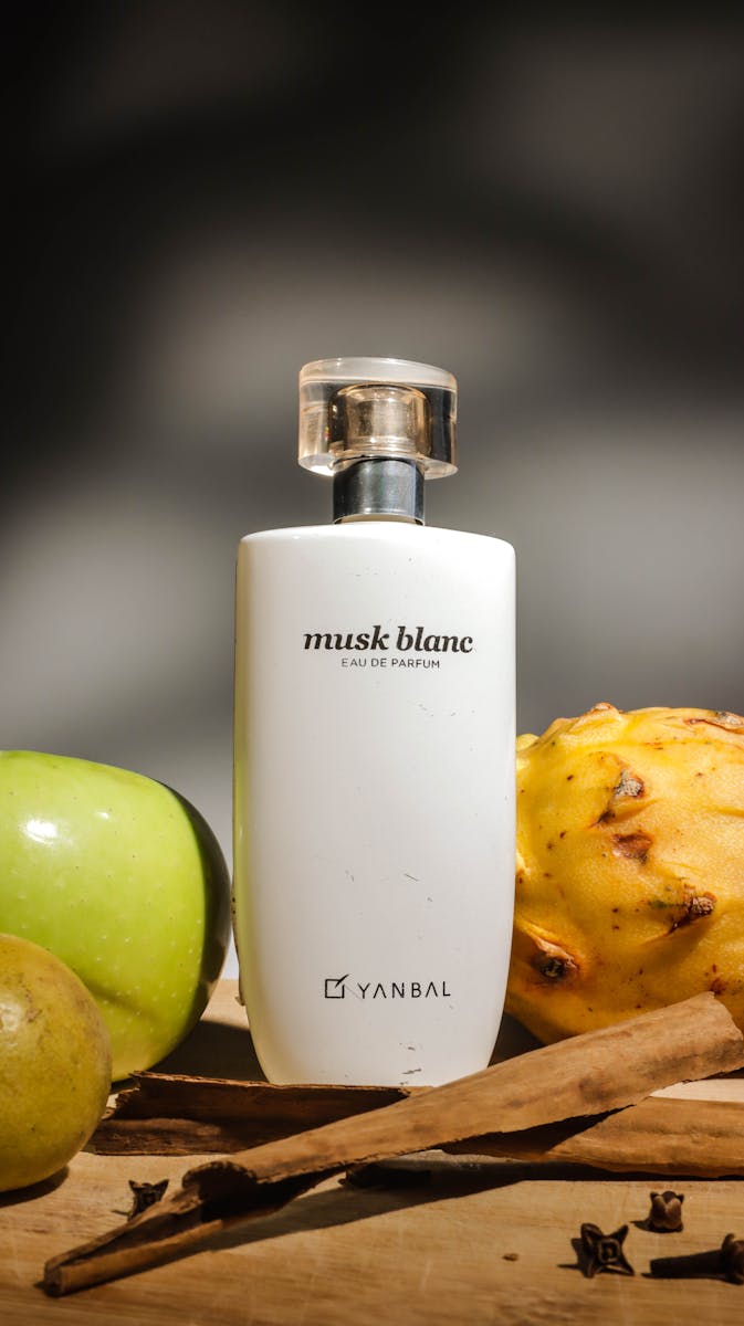 Still life of Musk Blanc Eau de Parfum with fruits and spices in a vertical shot.